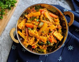 Vegetable Jalfrezi is a semi-dry curry made with a tangy colorful blend of stir fried mixed vegetables cooked in a thick spicy tomato base.