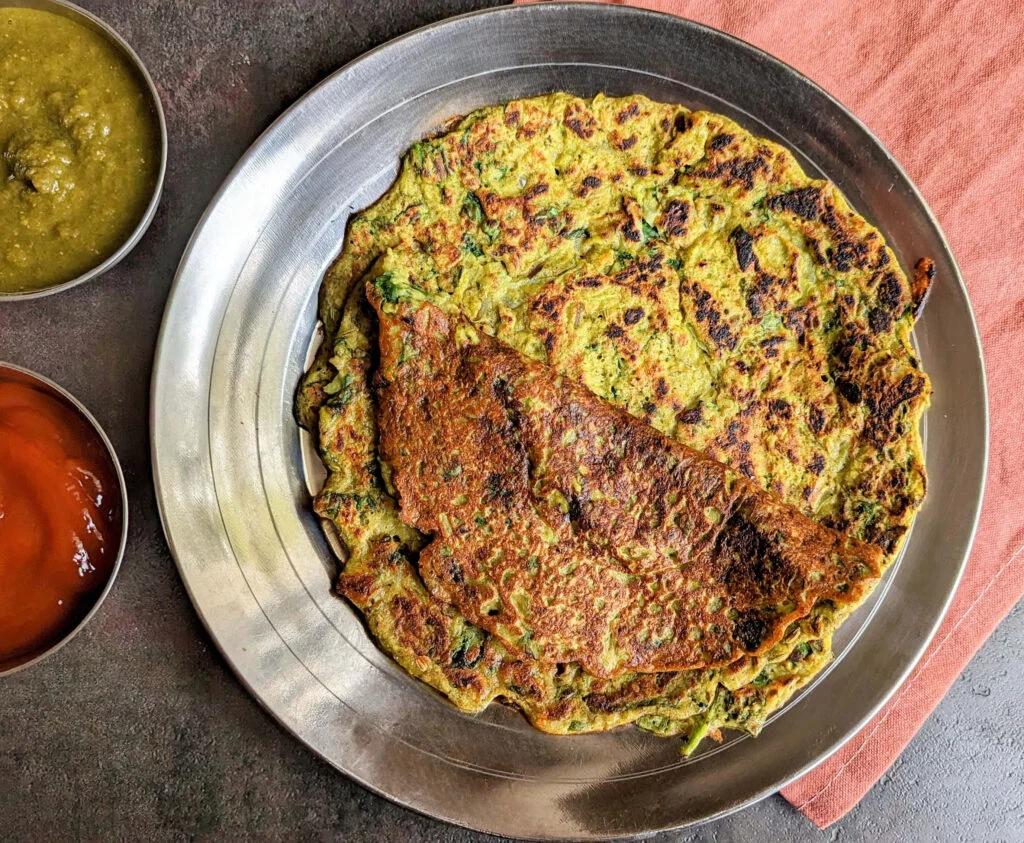 Green Moong Dal Chilla Recipe - Moong dal Chilla on steel plate with chutneys
