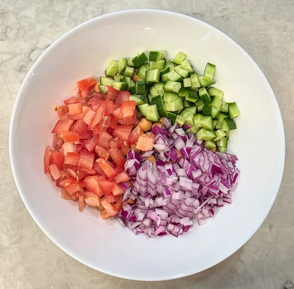 Chopped tomato, cucumber and red onion added over the chickpeas