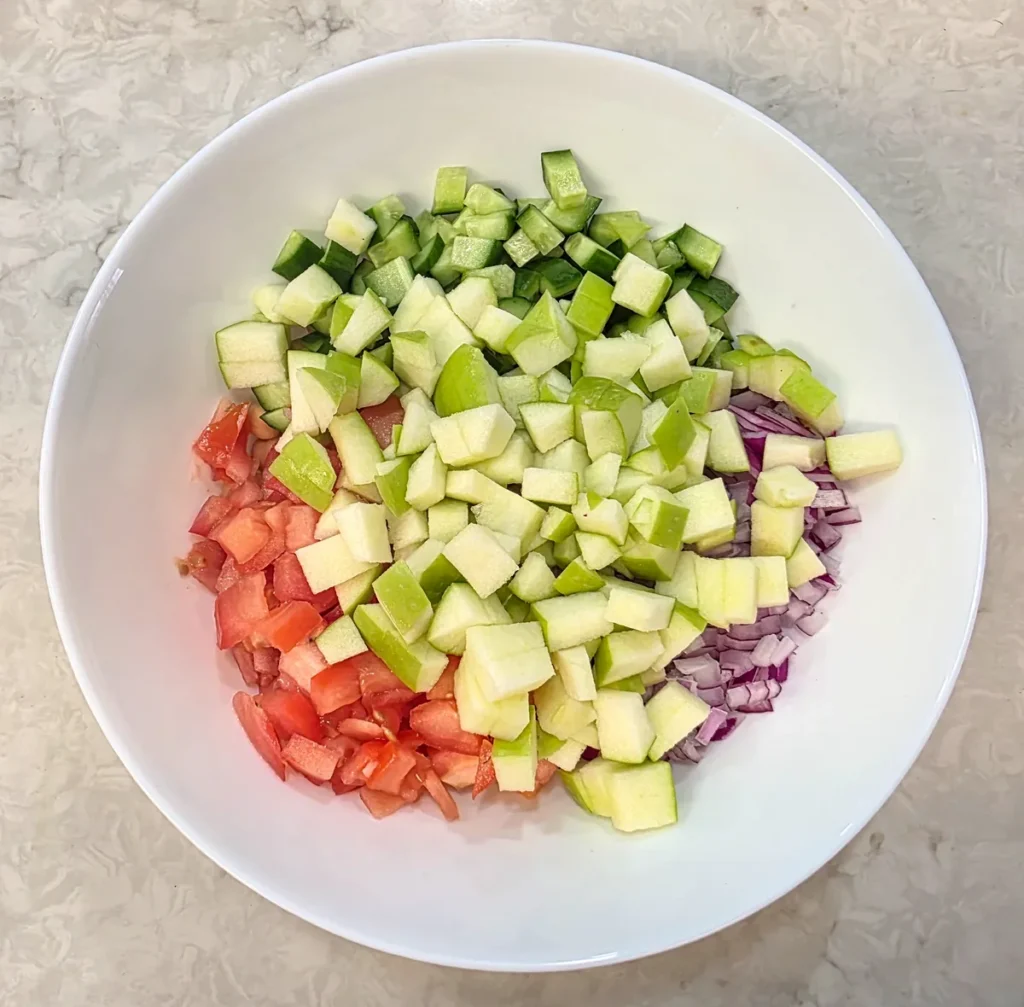 Diced green apple added to the chopped cucumber, tomato and onion
