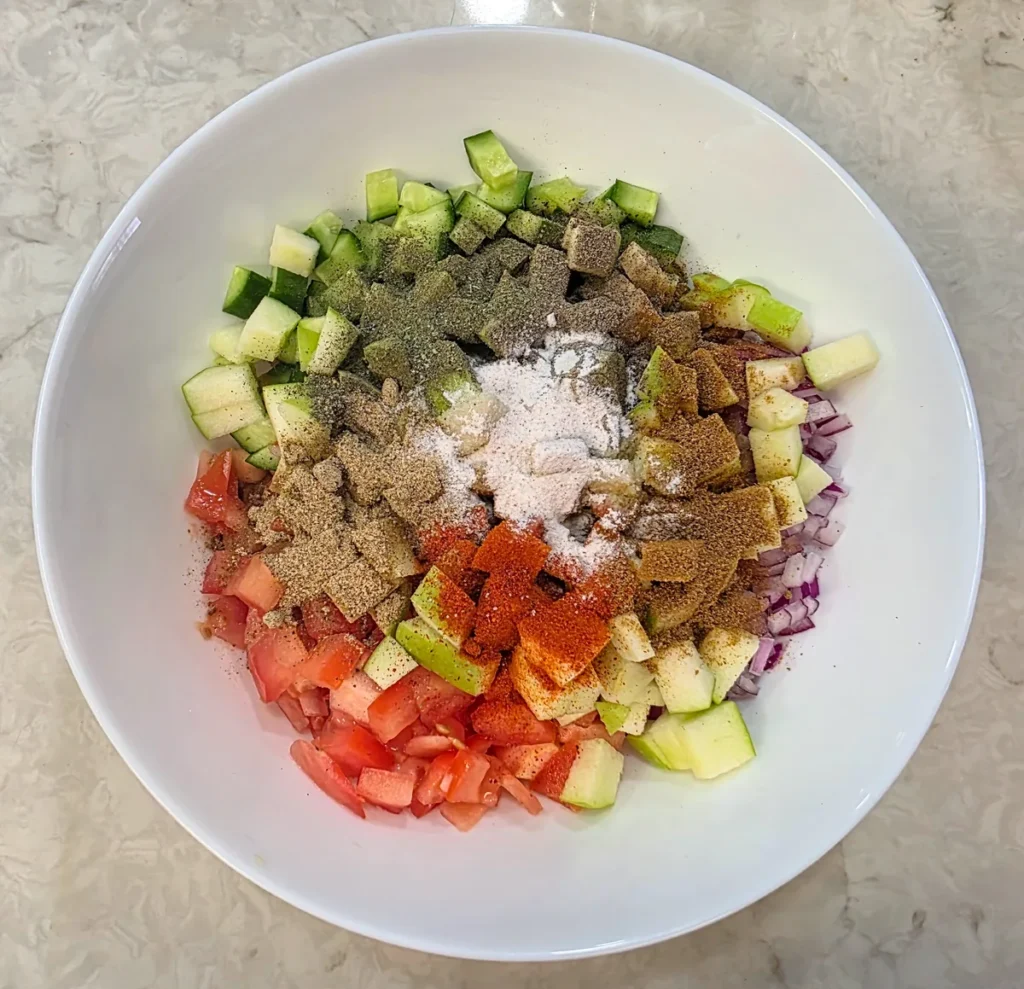 Roasted cumin powder, chaat masala, red chilli powder, black pepper and kala namak heaped over the chopped vegetables