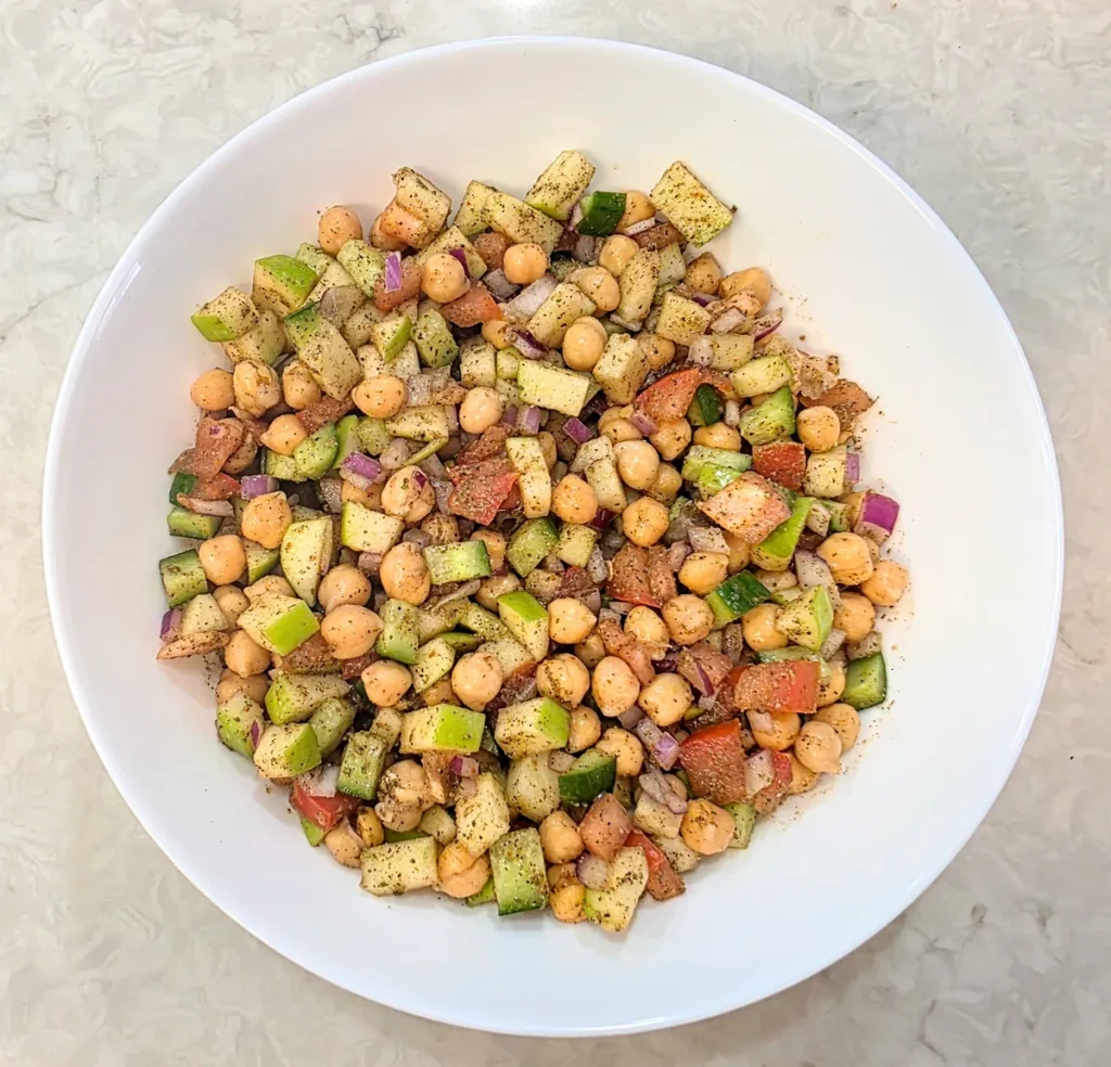 Chickpeas, apple and vegetables tossed together and evenly coated in the spices