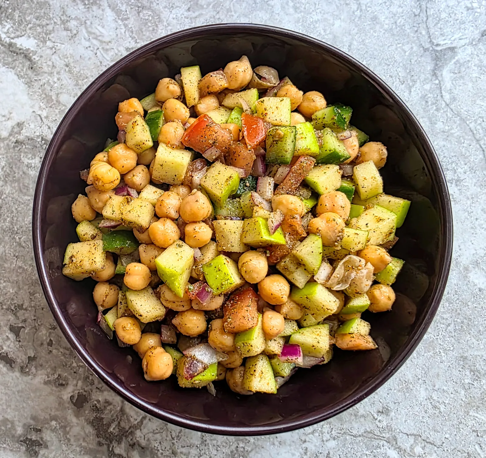 Apple chickpea kachumber salad served in a dark bowl